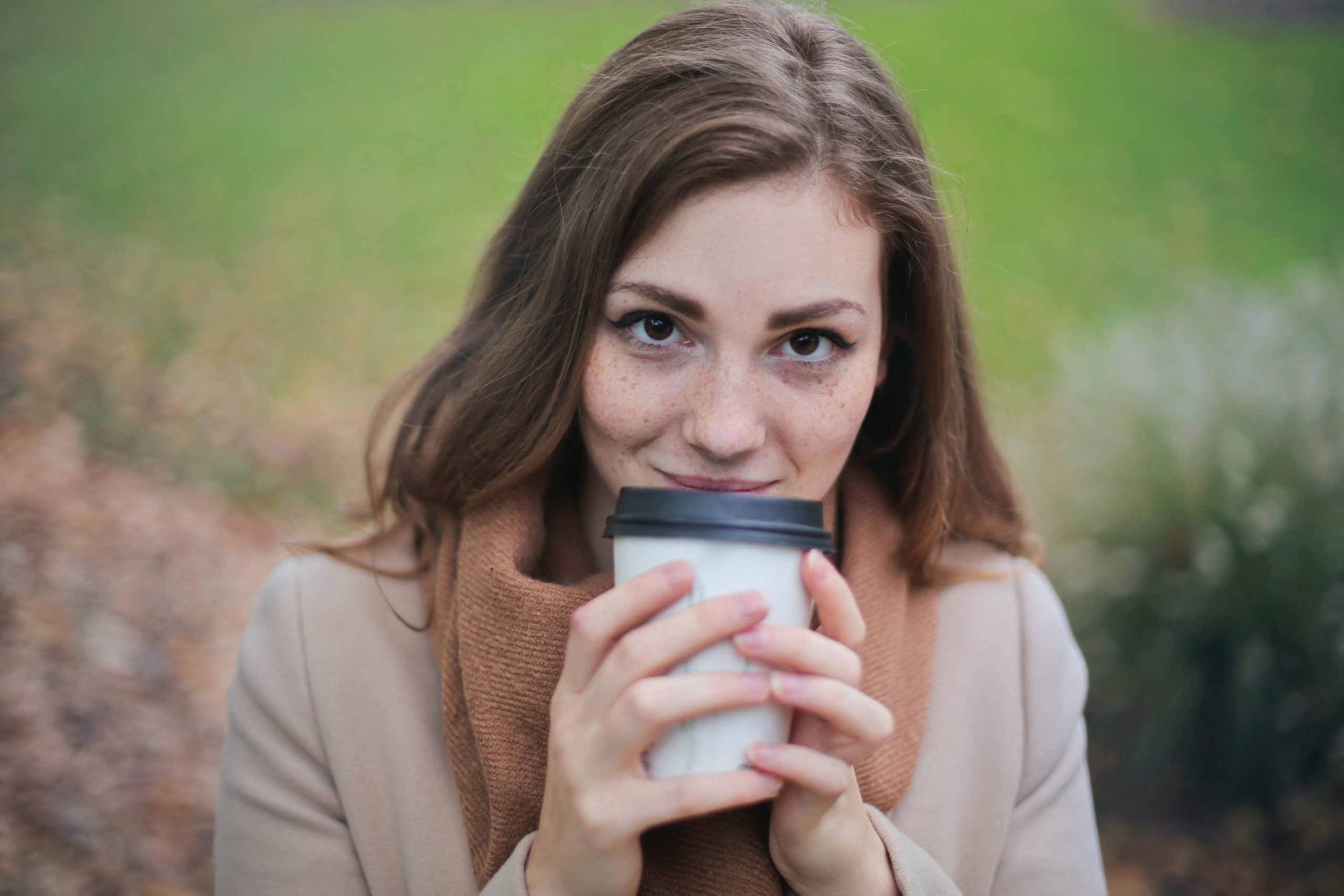 young woman holding a to -go coffee