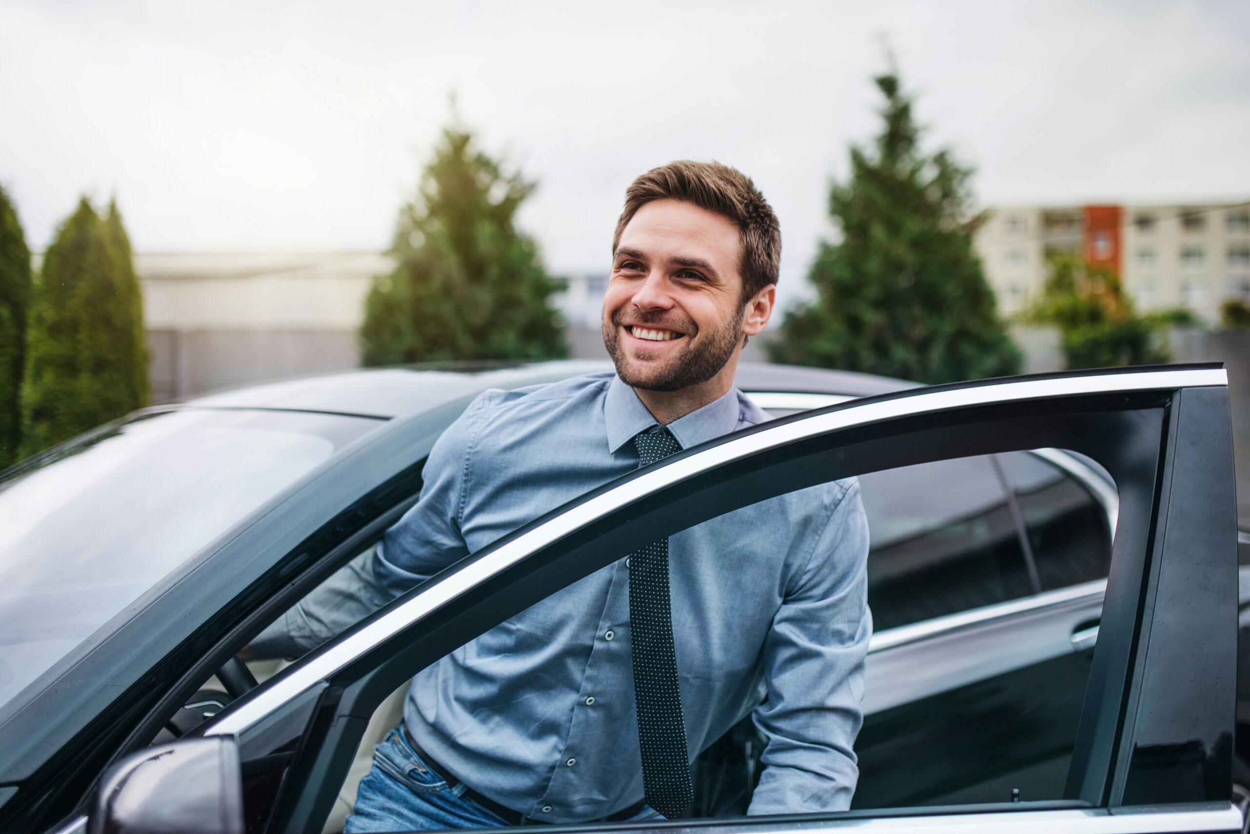 car salesman getting out of a car