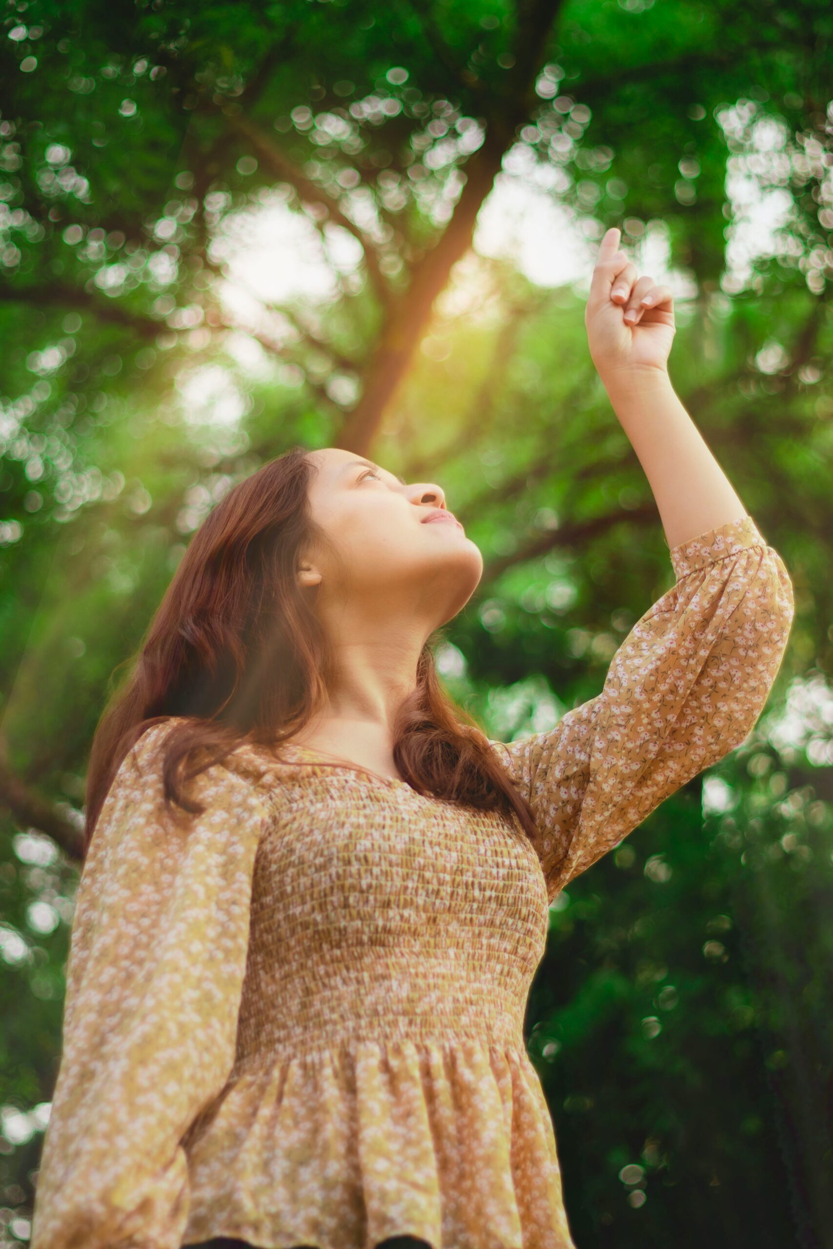 young woman pointing to God in heaven giving thanks