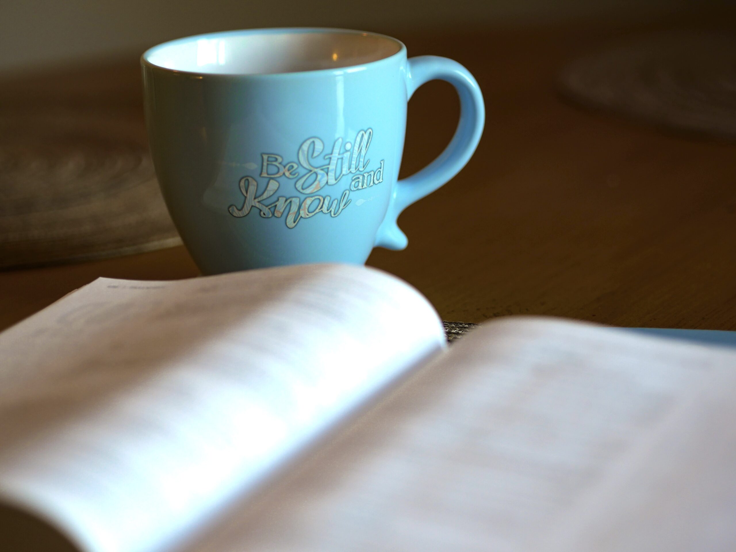 blue coffee mug with Be Still and Know printed on it